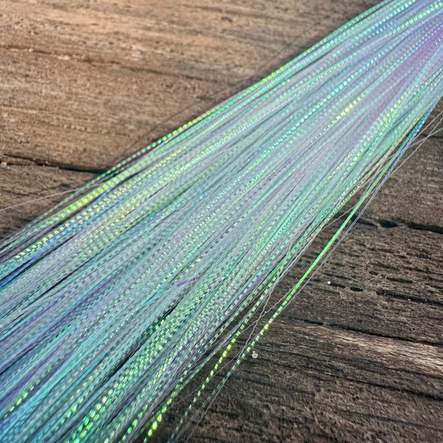 Close-up of UPAVON FLY FISHING Apex Predator Micro Scale Flash for fly tying, showing iridescent, reflective micro-scale material.